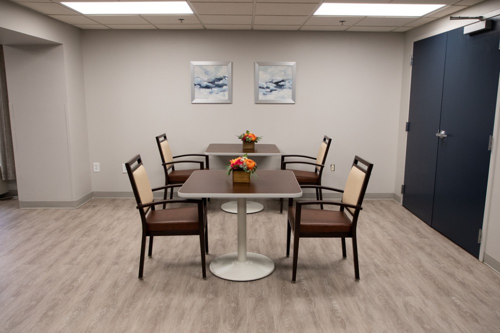 A modern conference room with a meeting table, chairs, and decorative flowers.