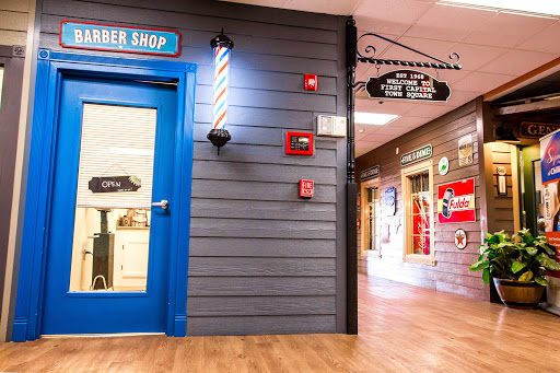 A vibrant interior of a barber shop featuring a blue door and traditional striped barber pole.