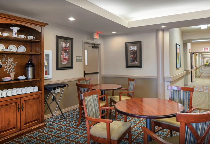 A cozy lounge area with round tables, chairs, and wall artwork.