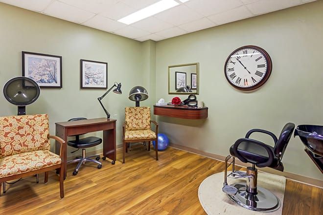A cozy office space with a desk, chair, and large wall clock.