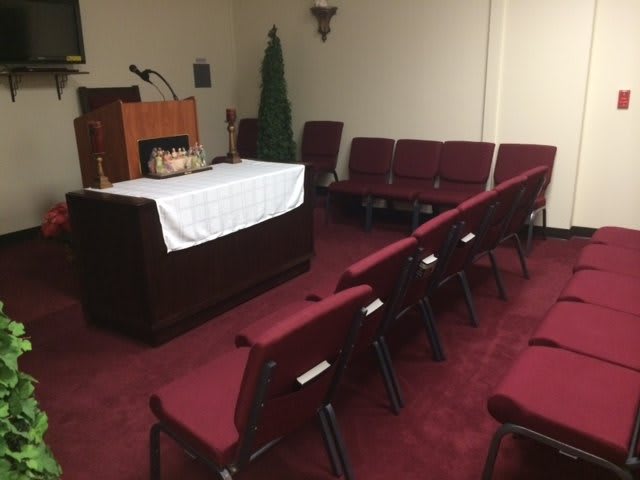 A small chapel with red seating and a podium at the front.