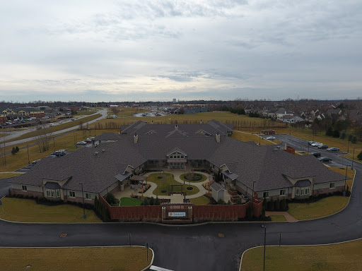 An aerial view of a residential complex featuring green spaces and pathways under a cloudy sky.