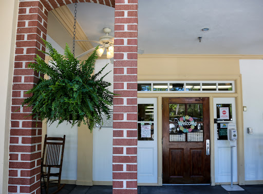 A welcoming entrance featuring a brick facade and a hanging fern.