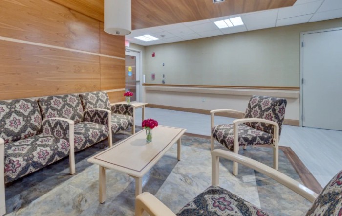 A modern waiting room with patterned seating and a simple wooden table.