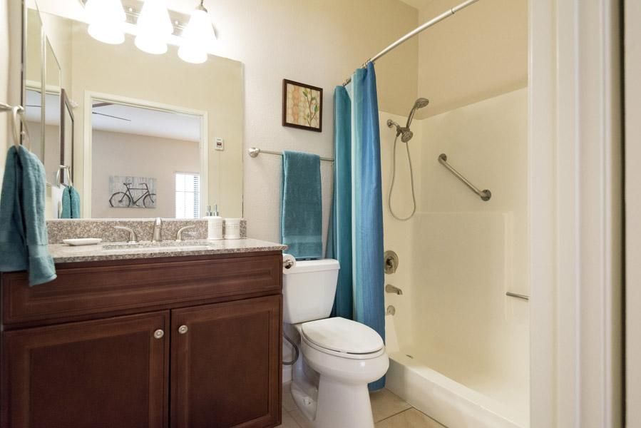 A clean and modern bathroom with a shower, toilet, and sink.