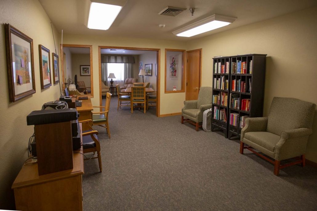 A cozy office space with a bookshelf and comfortable seating.