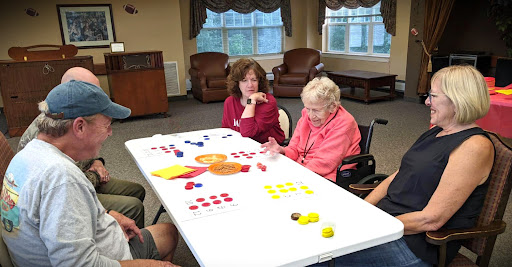 Seniors engaging in a fun tabletop activity at a community center.