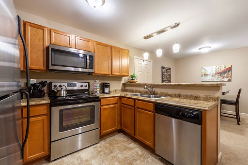 A contemporary kitchen featuring modern appliances and wooden cabinetry.