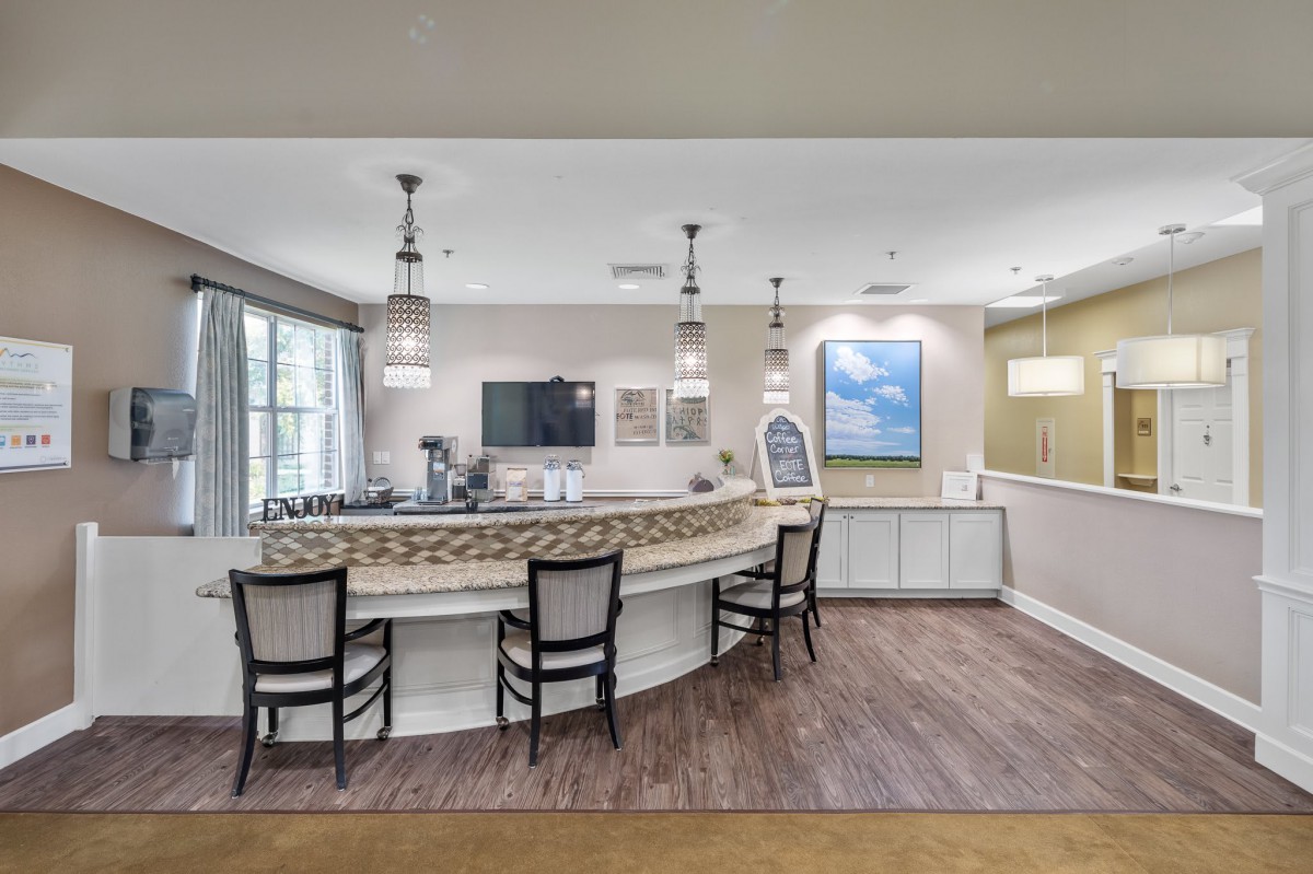 A modern reception area featuring a curved counter, stylish chairs, and elegant lighting.
