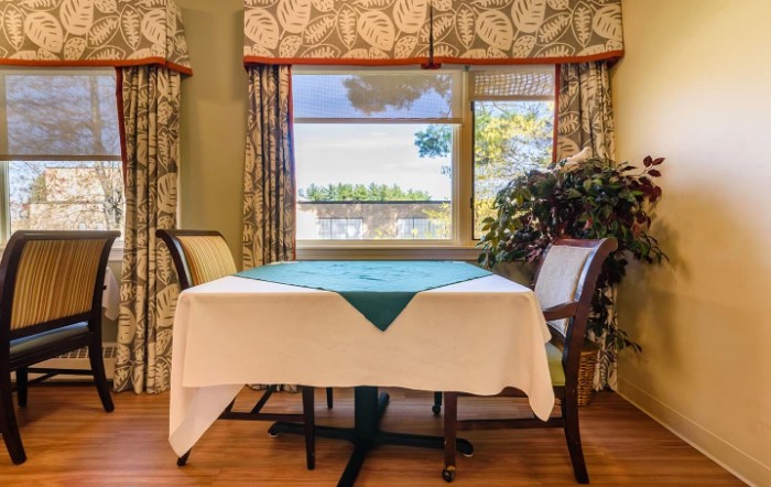 A cozy dining area with a table set near a window showcasing a scenic view.