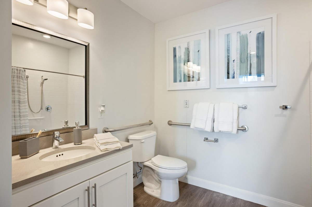 Modern bathroom with sink, toilet, and wall-mounted towels