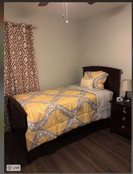 A cozy bedroom with a single bed and yellow bedding.
