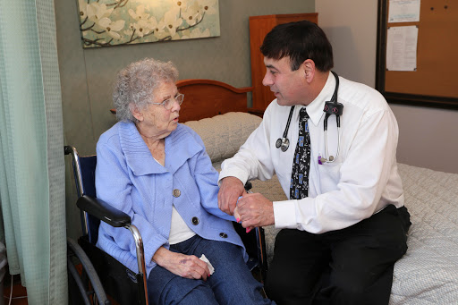 A doctor consulting with an elderly patient in a healthcare setting.