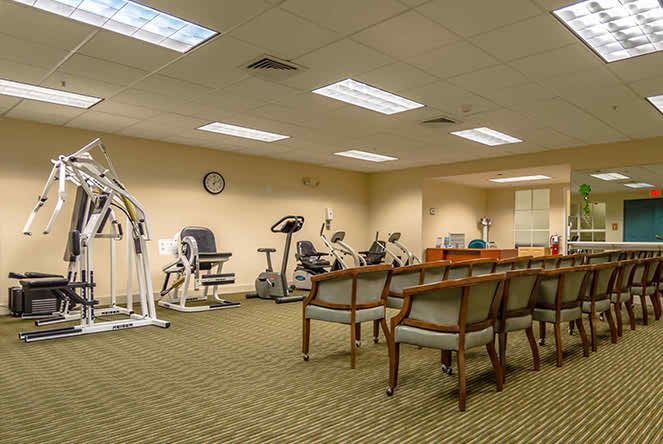 A small indoor gym with exercise machines and seating area.