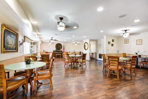 A spacious and welcoming dining area featuring wooden furniture and bright lighting.