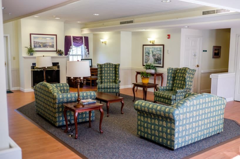 A cozy living room with patterned armchairs and wooden coffee tables.
