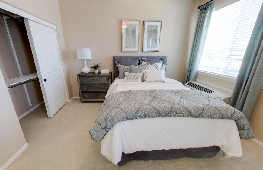 A cozy bedroom with a neatly made bed, nightstand, and decorative elements.