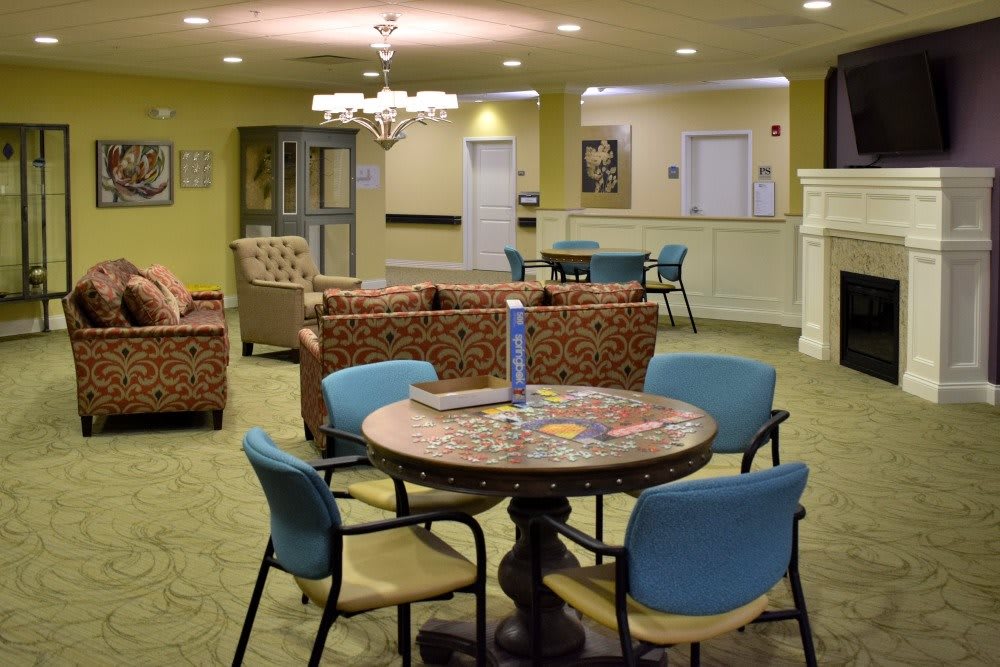 A cozy lounge area with comfortable seating and a central table, featuring warm lighting and modern decor.