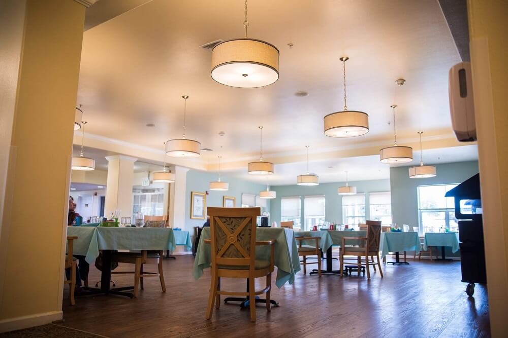An empty restaurant dining area with neatly arranged tables and chairs.