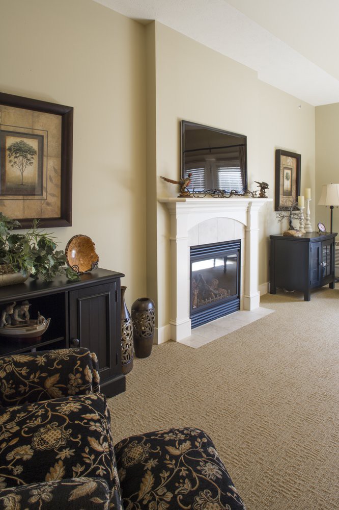 A cozy living room featuring a central fireplace, elegant furniture, and tasteful decor.