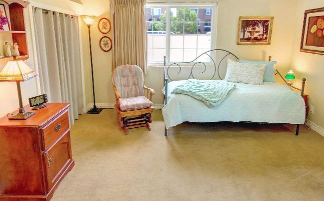 A cozy bedroom with a bed, rocking chair, and window.