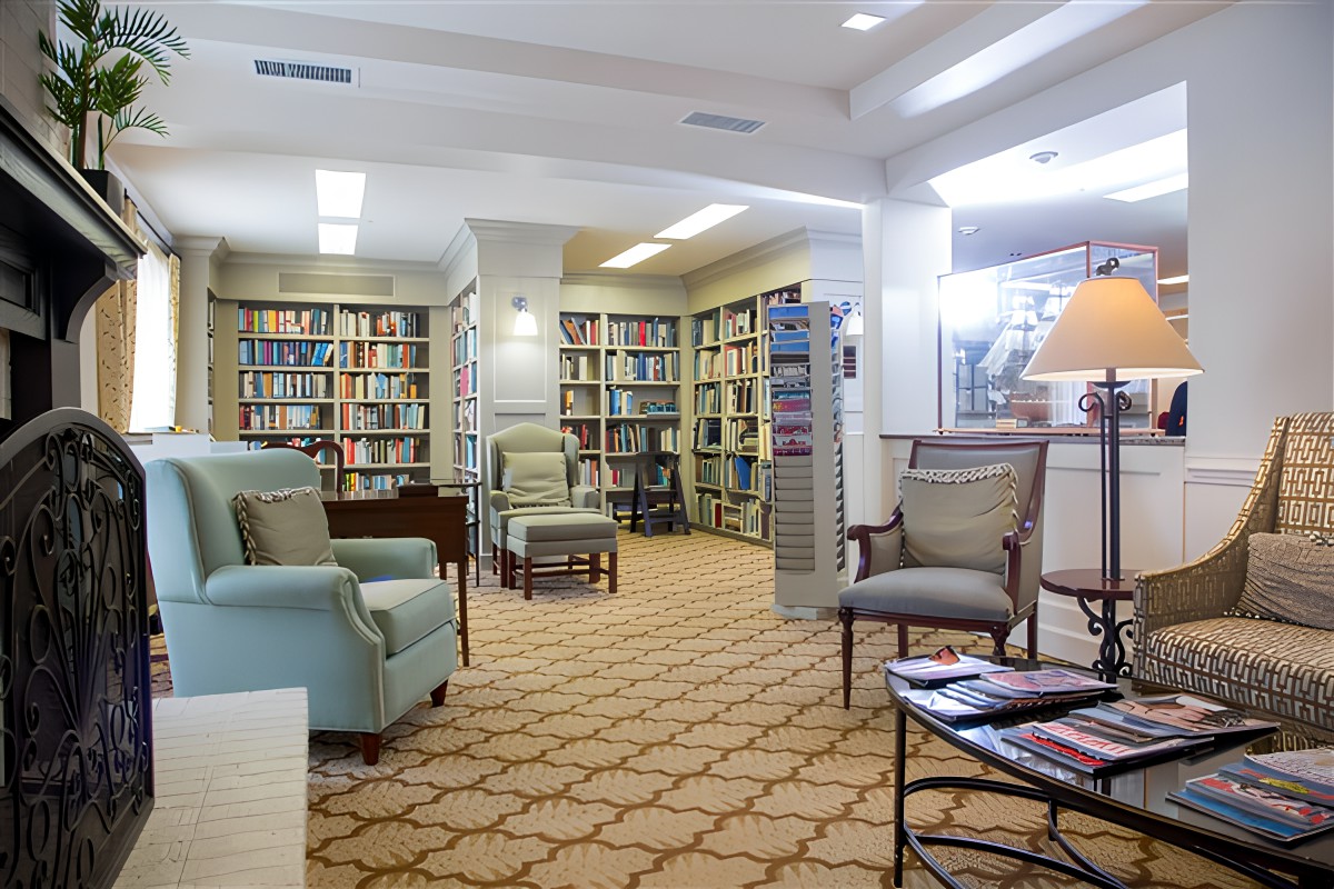 A cozy library reading area with comfortable armchairs and bookshelves filled with a variety of books.
