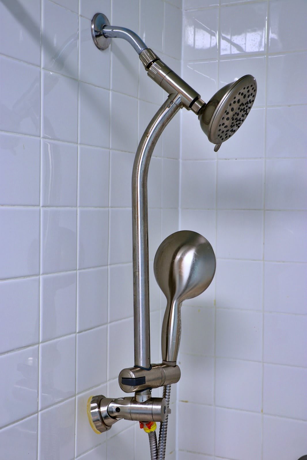 Modern showerhead with a sleek design installed on tiled wall.