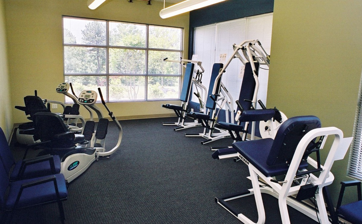 A bright and clean gym with exercise machines arranged neatly.