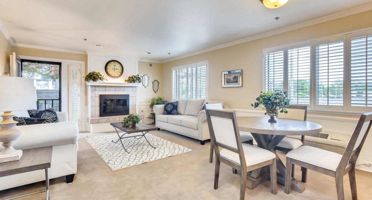 A cozy and modern living room featuring a sofa, table, fireplace, and tasteful decor.