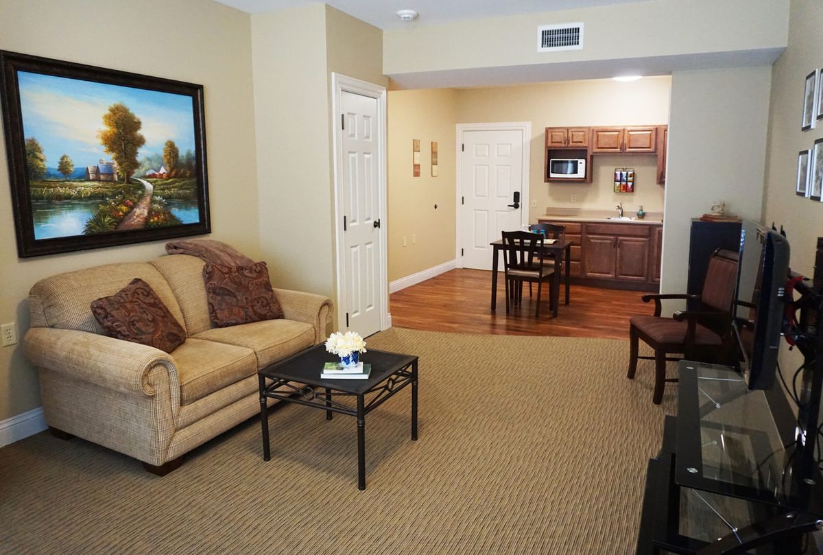 A cozy living space with a sofa, table, and kitchenette.