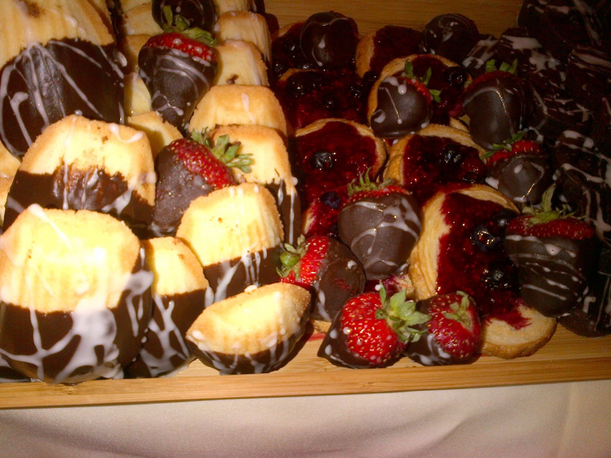 A delectable assortment of chocolate-covered strawberries and mini cakes.