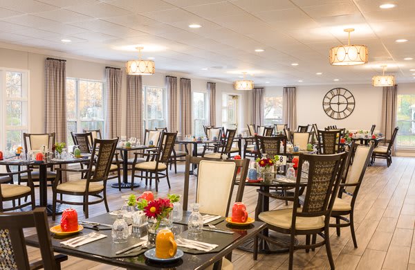 A neatly arranged dining room with tables set for guests.