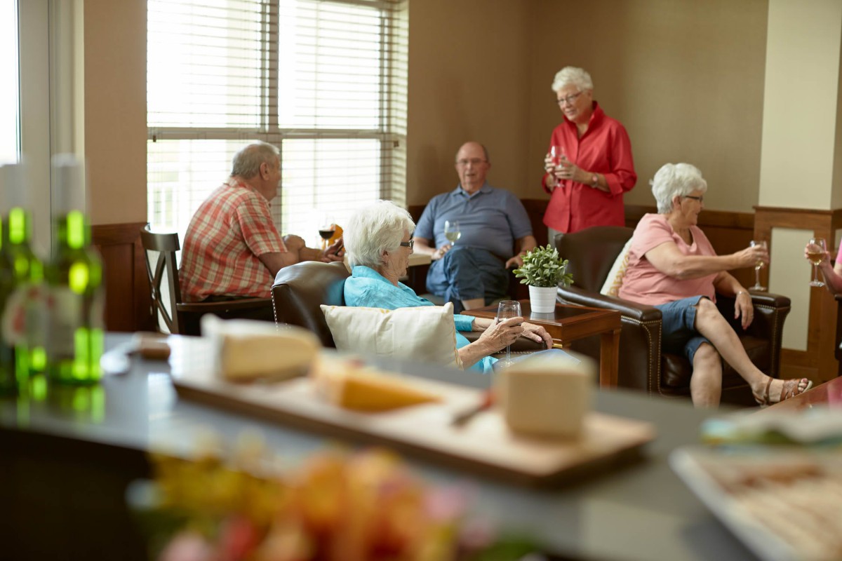 A group of seniors enjoying a conversation in a cozy living room setting.