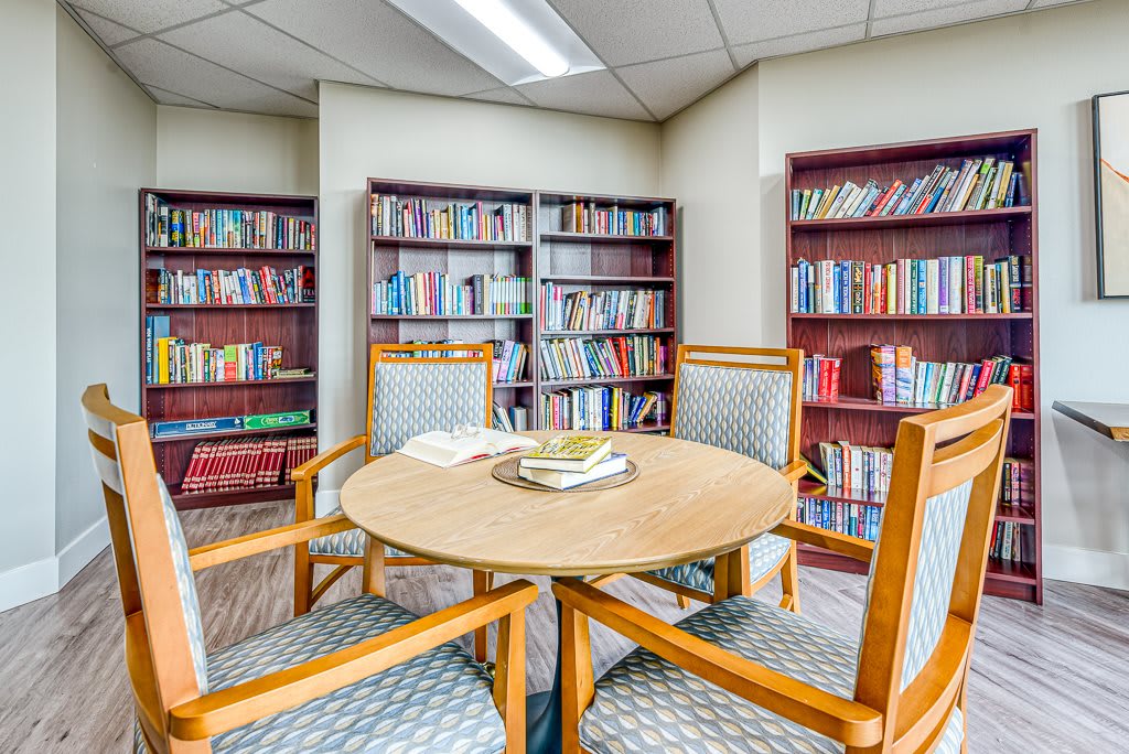 Cozy library corner with a round table and bookshelves filled with books.
