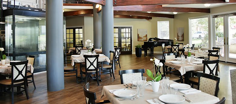 Elegant restaurant dining area with neatly set tables and a grand piano.