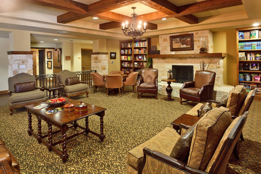 A cozy living room with traditional decor, featuring a fireplace and bookshelves.