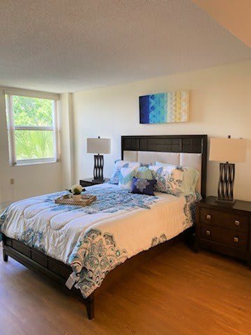 A well-decorated bedroom with a large bed, nightstands, and stylish artwork on the wall.