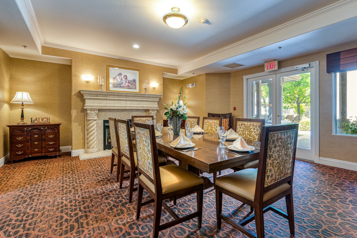 A well-appointed dining room with elegant furnishings, featuring a fireplace and large table surrounded by chairs.