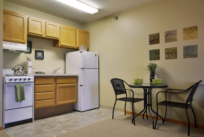 Small apartment kitchen with a dining table and chairs.