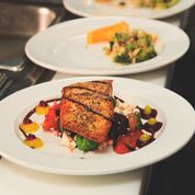 A beautifully plated dish featuring grilled salmon on a bed of colorful vegetables.