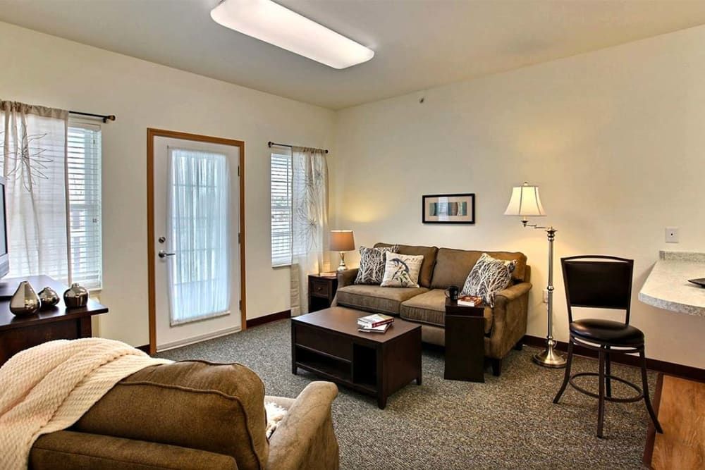 A cozy living room with sofas, a coffee table, and soft lighting.