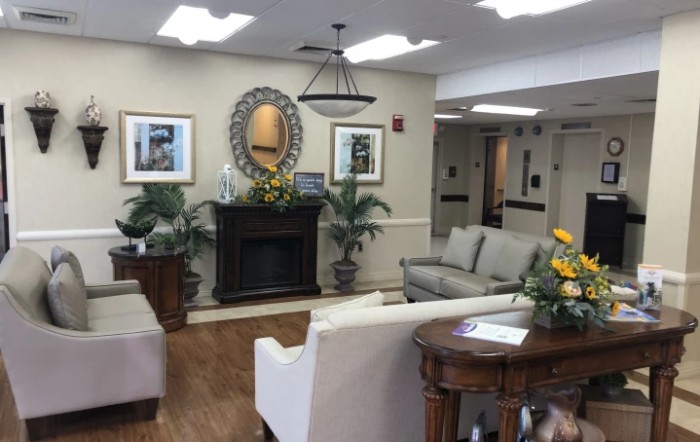 A warmly decorated lobby with comfortable seating, a fireplace, and various decorative elements.