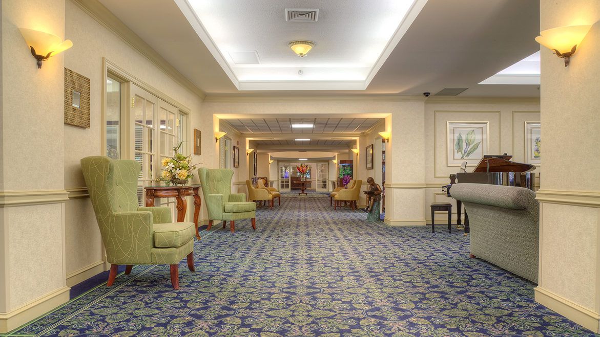 A hotel hallway with seating areas and decorative lighting.