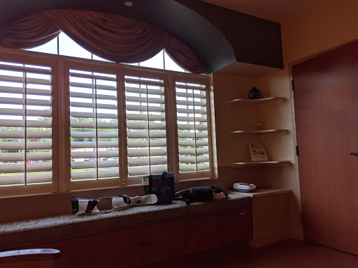 A cozy room featuring a window with blinds and open shelving.