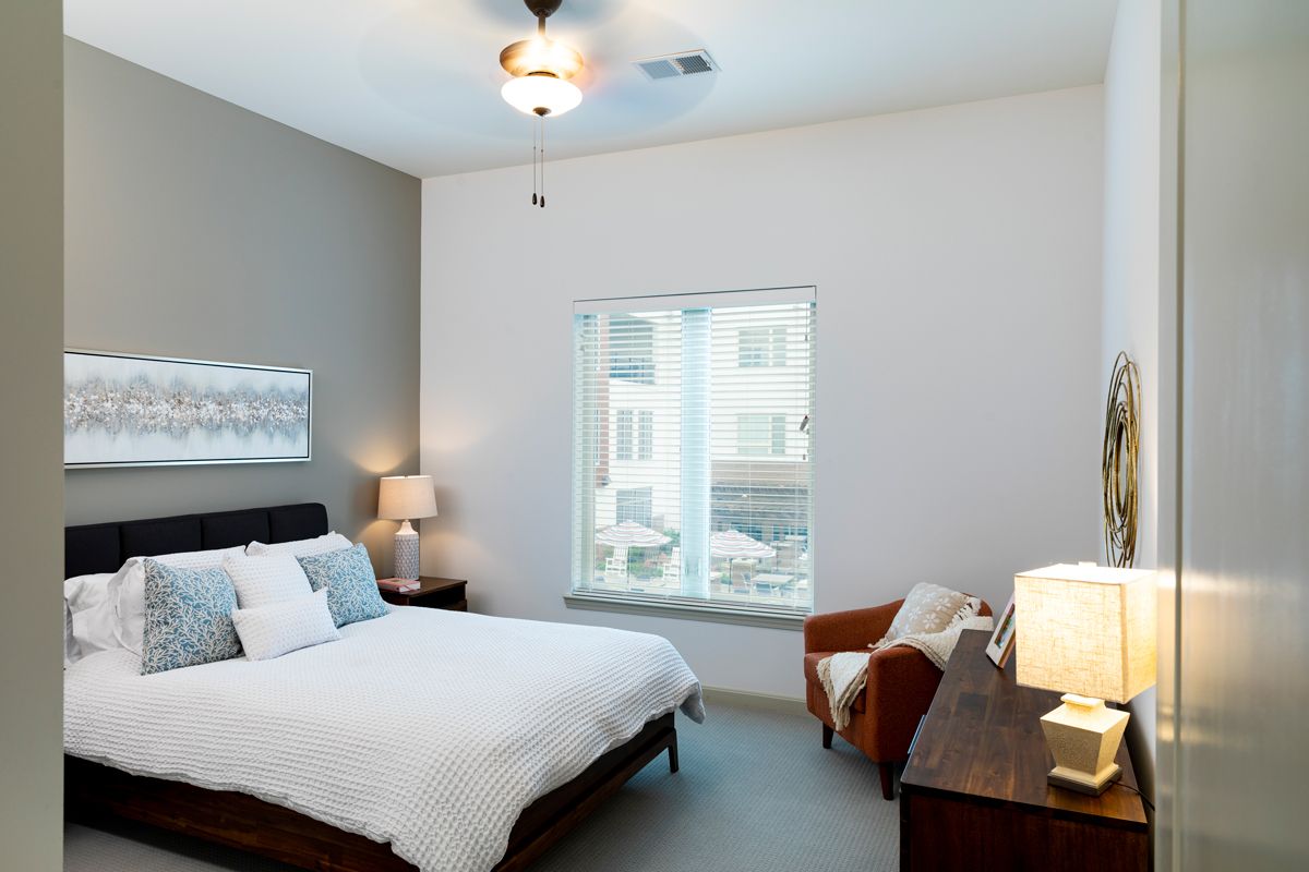 A modern bedroom with stylish decor and large window.