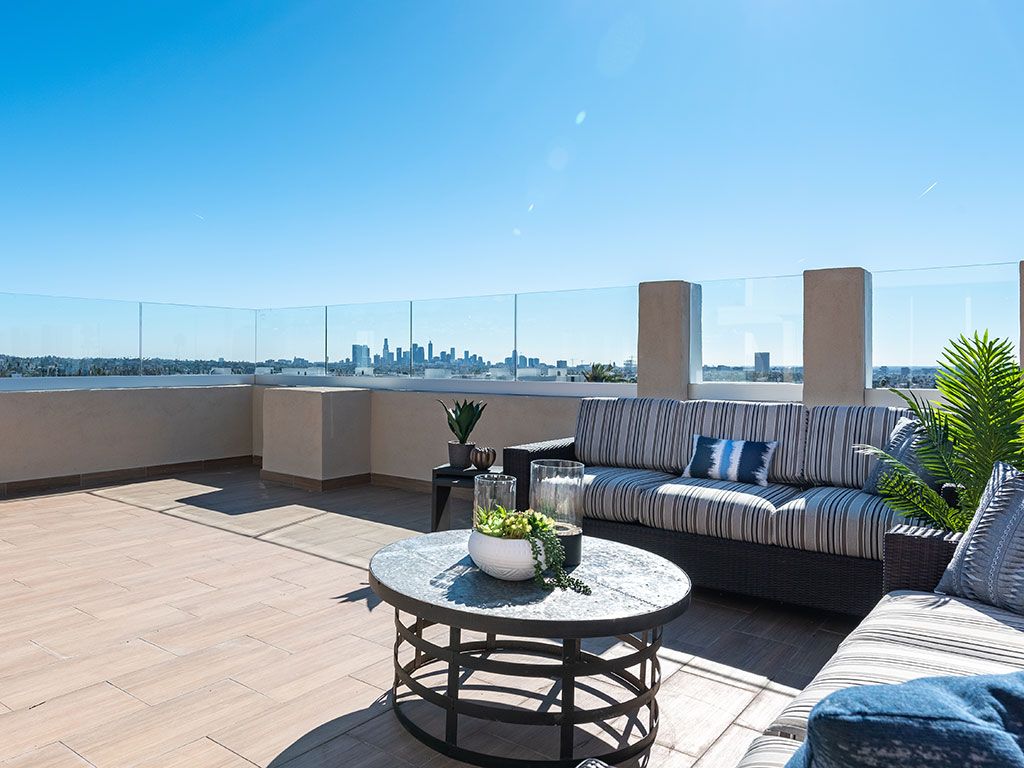 A stylish rooftop patio with comfortable seating and a view of the city skyline.