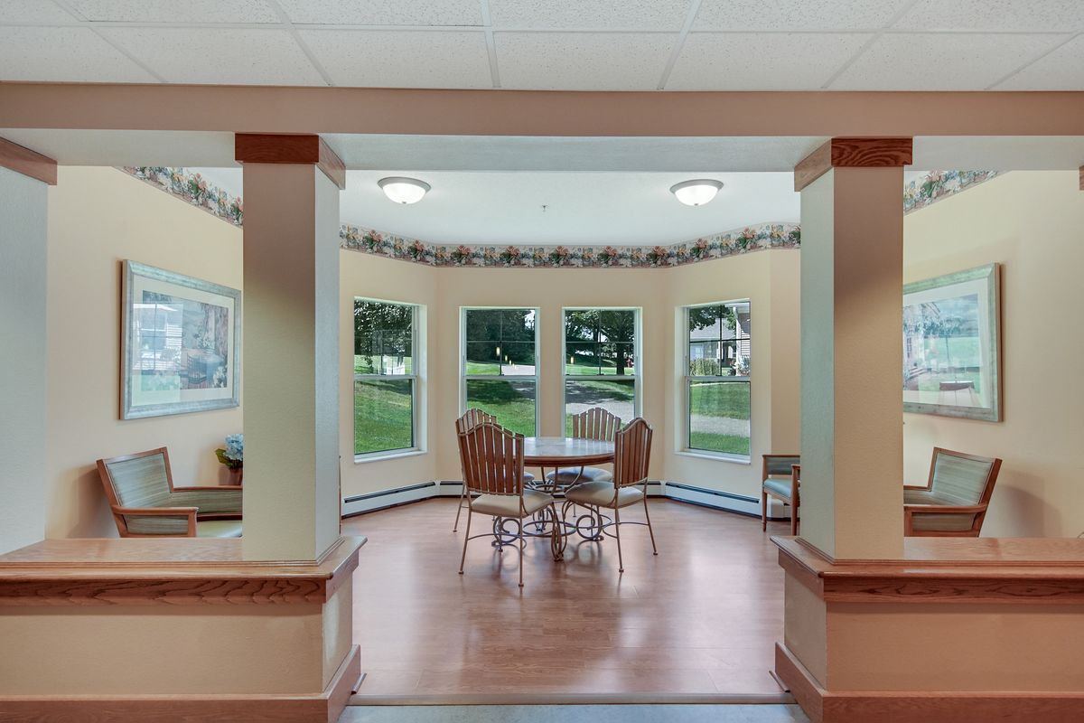 A cozy dining area with large windows allowing natural light to fill the space.