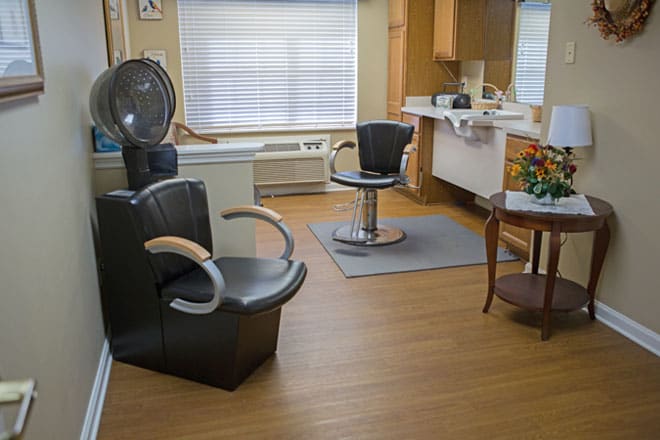 A cozy hair salon with styling chairs and a dryer station.