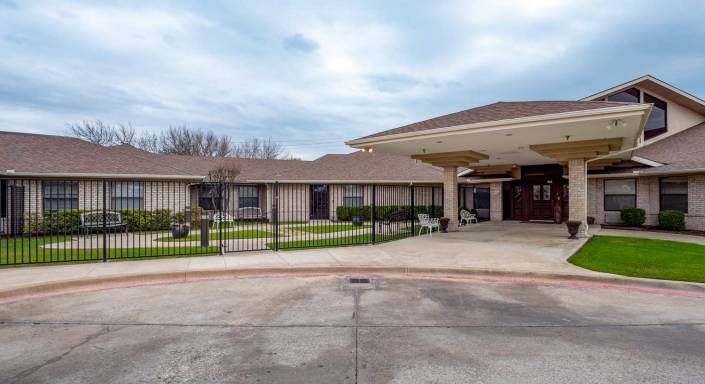 A view of a building with an entrance and gated driveway.