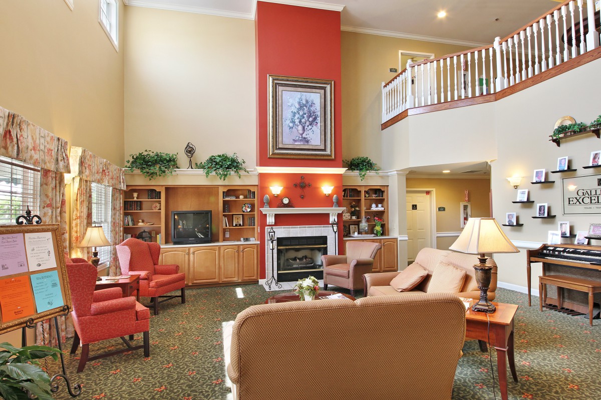 A cozy living room with a fireplace, comfortable seating, and built-in bookshelves.